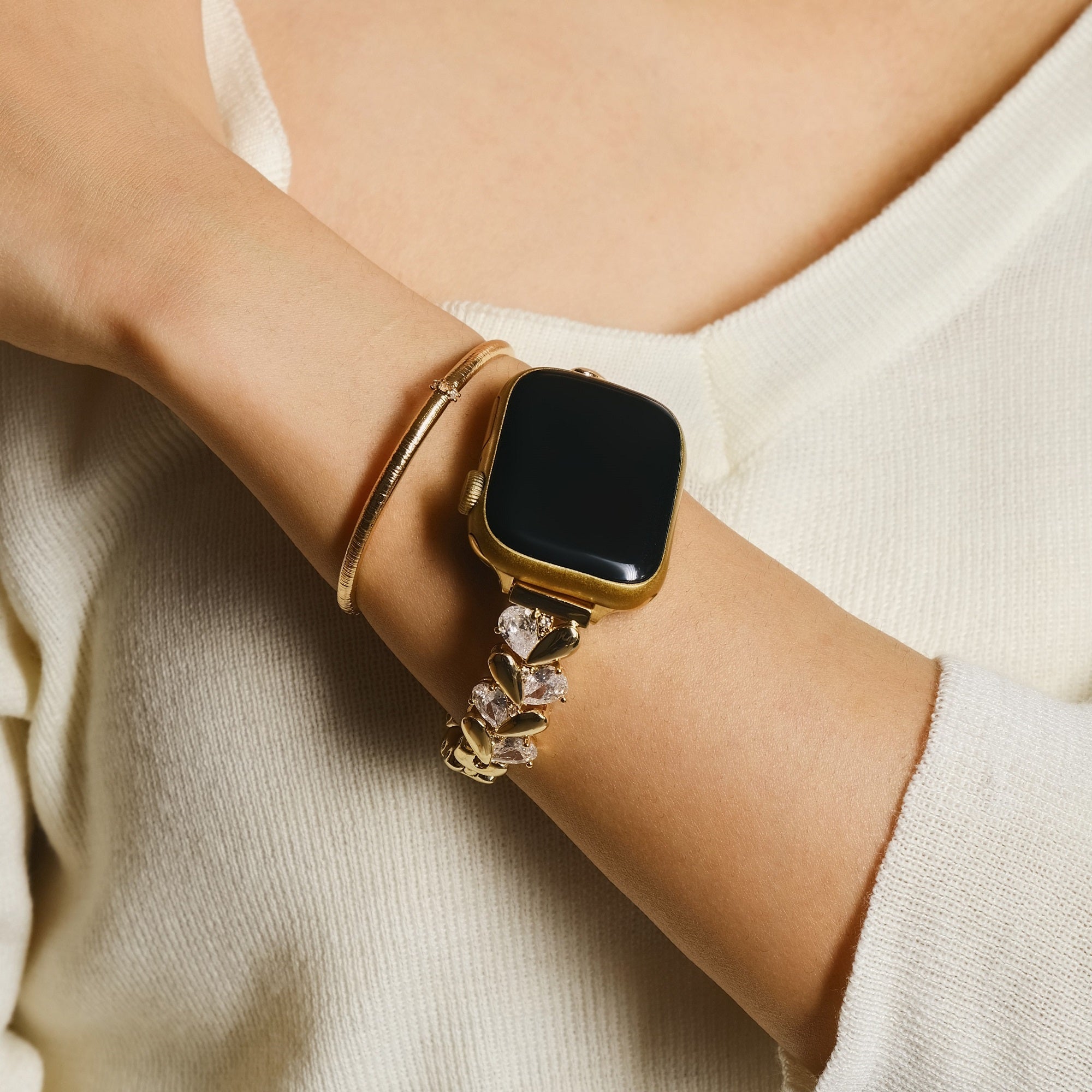 Woman wearing copper rhinestone Apple Watch band with love heart metal bracelet