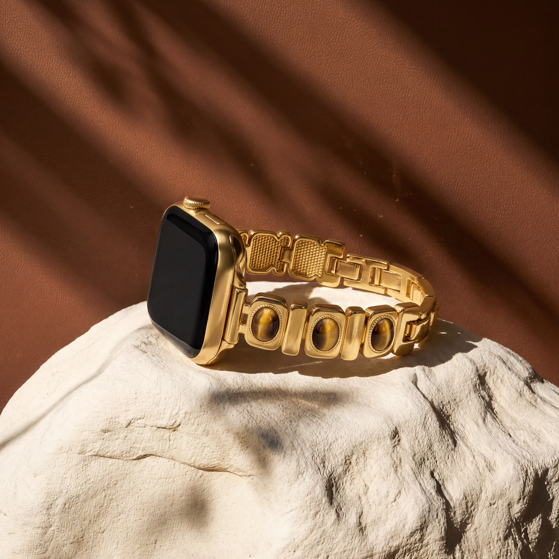 Gold smartwatch band on a textured surface with a brown background