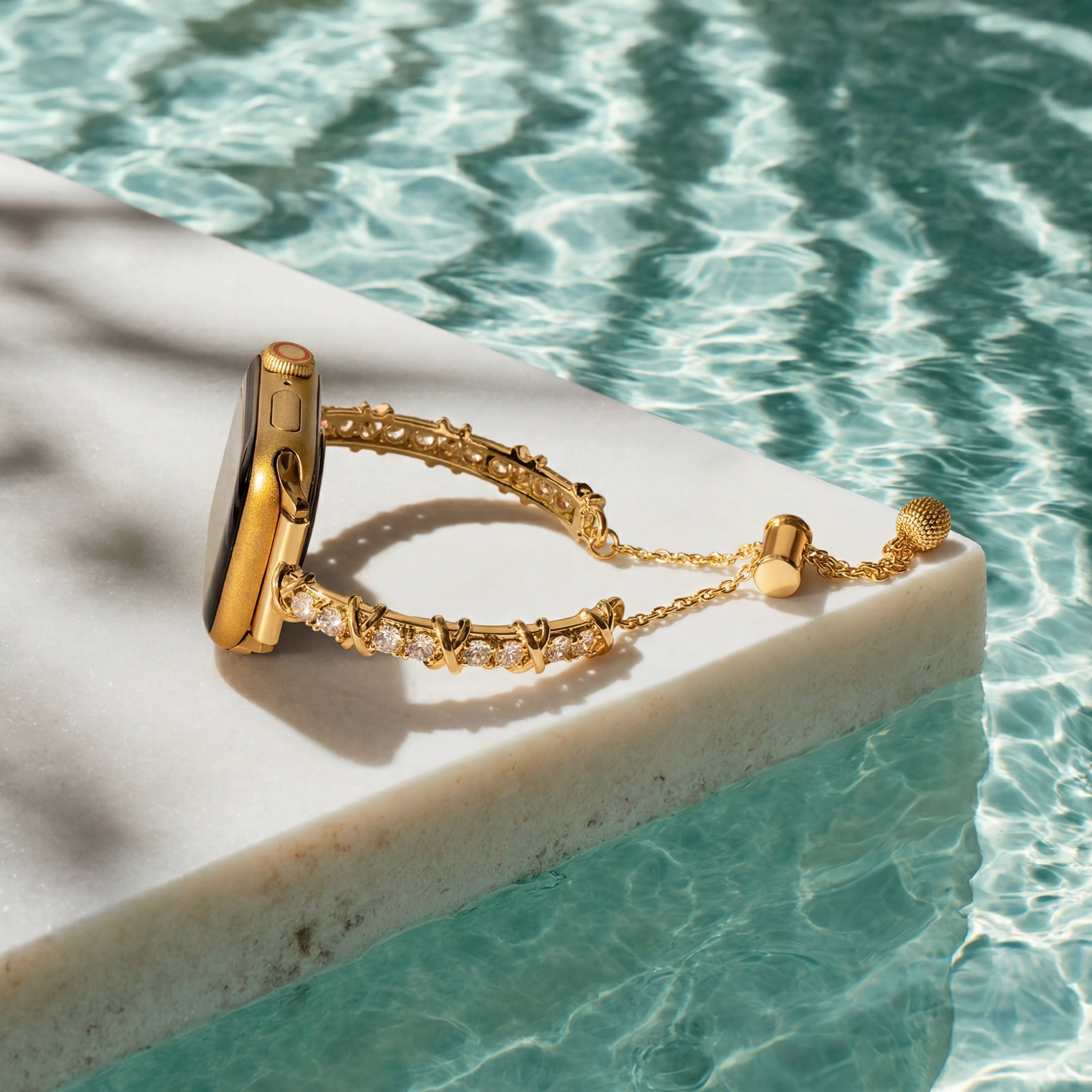 Gold bracelet on a pool ledge with clear water in the background