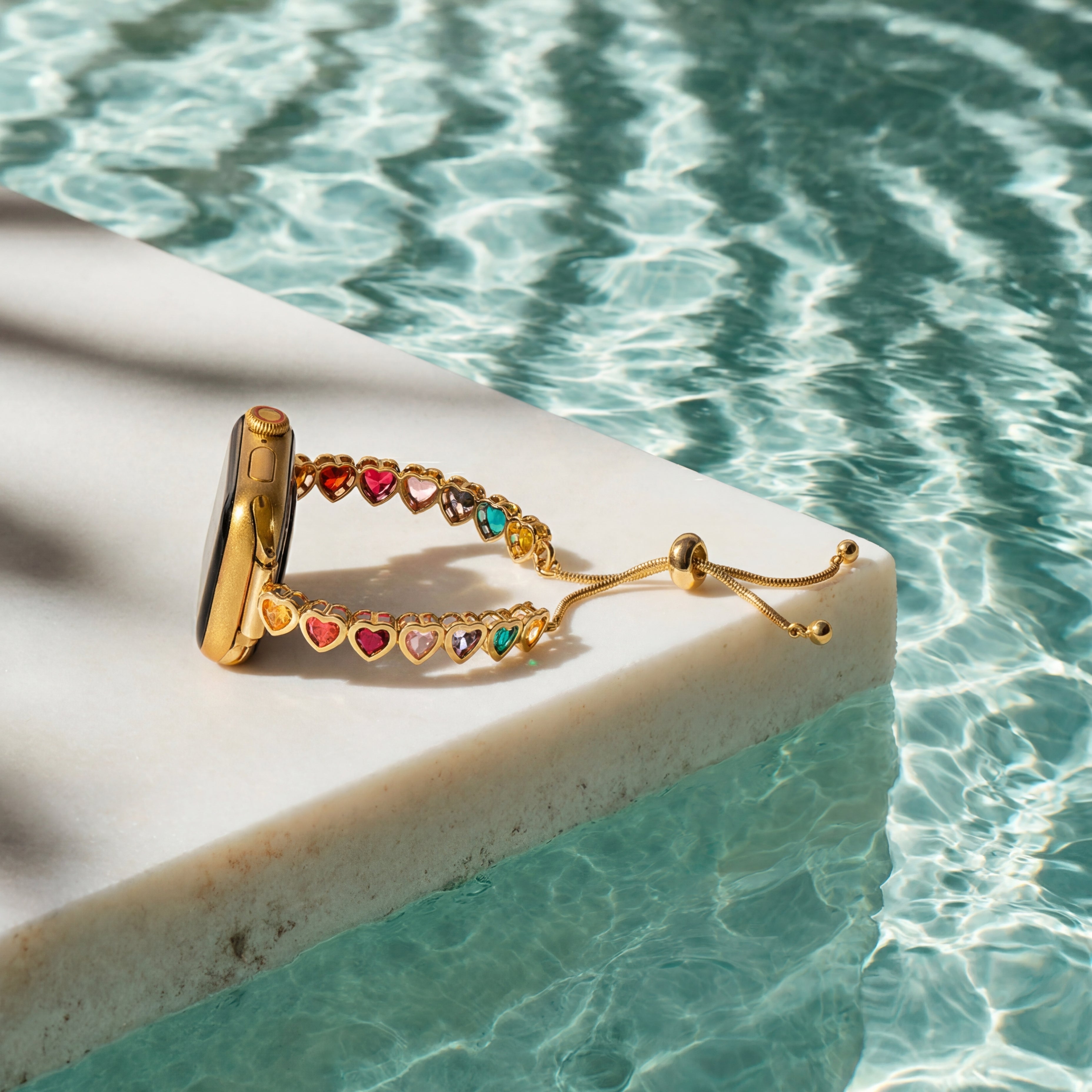Gold ring with colorful gemstones on a ledge by a pool